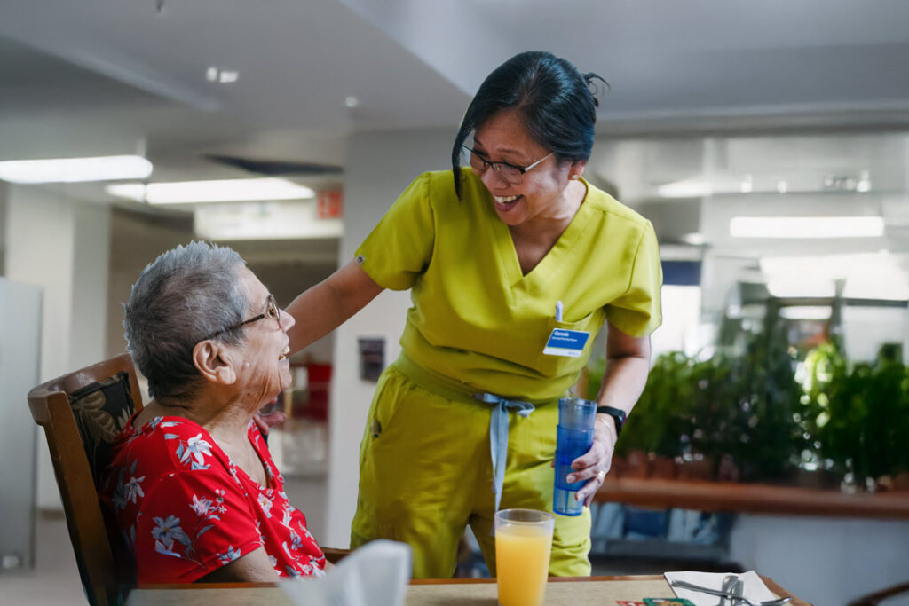 Caregiver interacting with elderly resident.